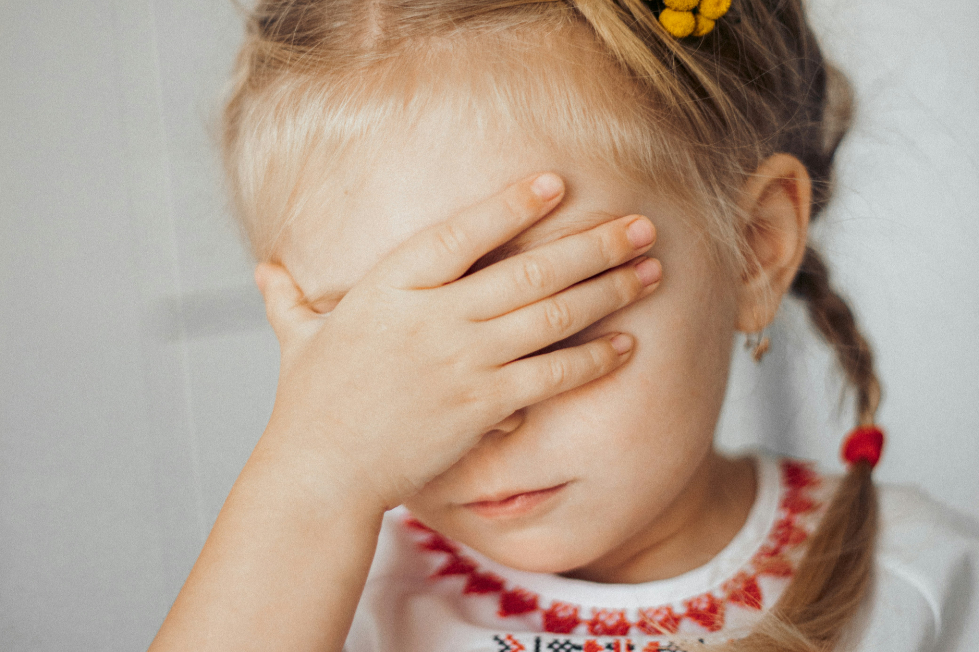 A young girl holds her head